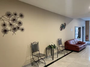 Salle d'attente d'une chambre funéraire avec fauteuil en cuir et chaises.