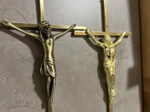 Christ sur croix en métal doré pour ornementation de monument funéraire.