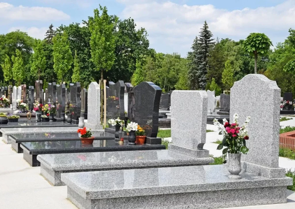 Cimetière moderne avec pierres tombales et dalles funéraires en granit gris.